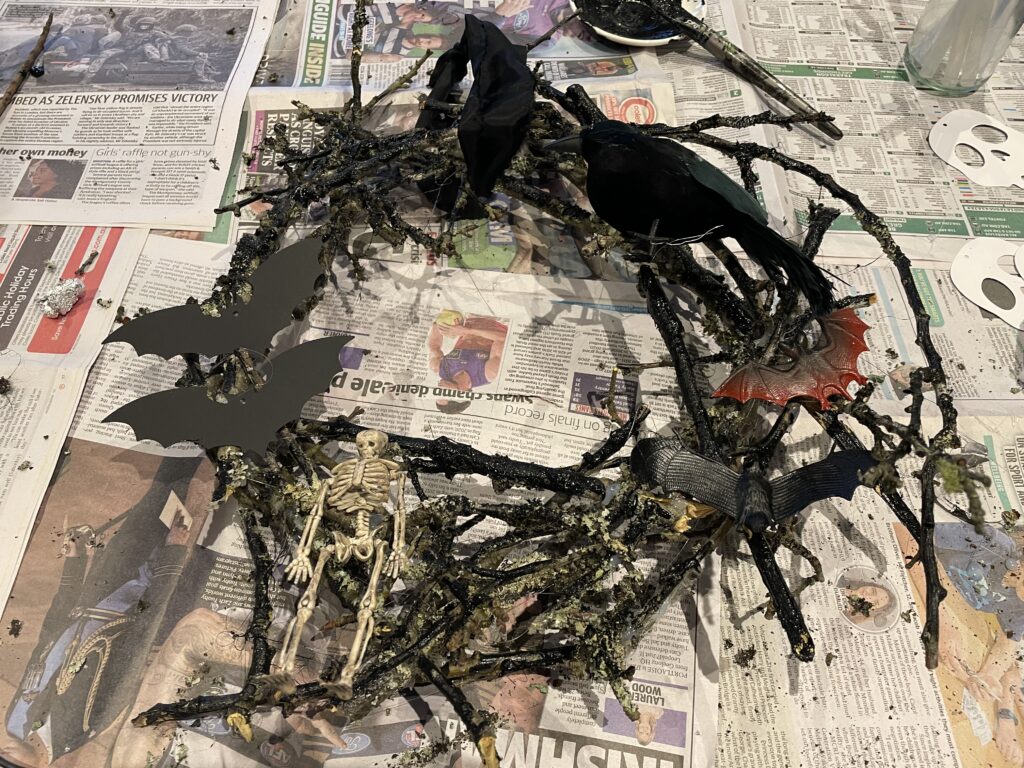 corona espeluznante de Halloween, pintada de negro con decoraciones de Halloween.